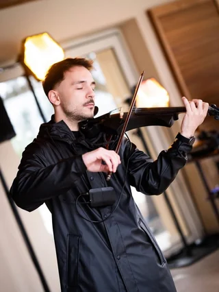 A violinist playing a black violin