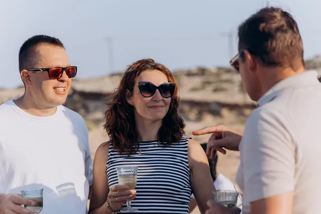 Serhiy and Anna chatting with a guest by the sea