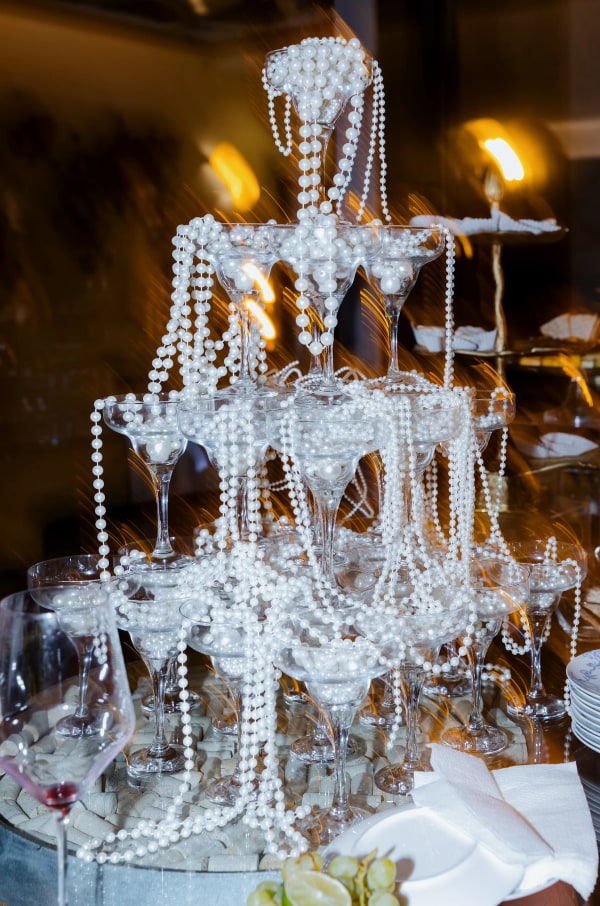 A tower of coupe glasses decorated with strands of pearls