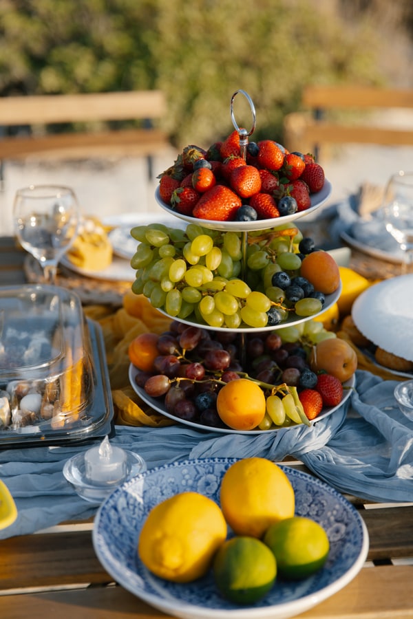 Blue-and-white plates, yellow accents and fruit on a seaside picnic table