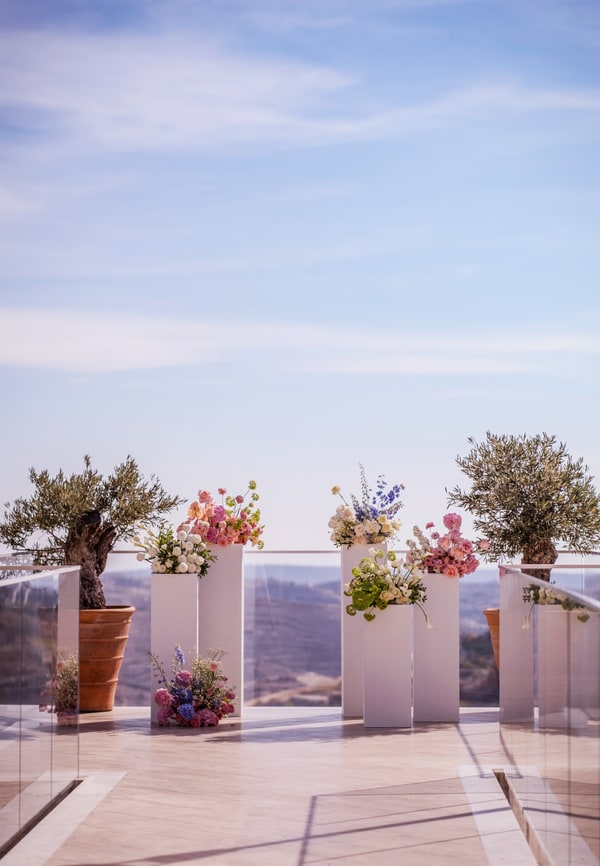 Flower arrangements on pedestals on an outdoor terrace
