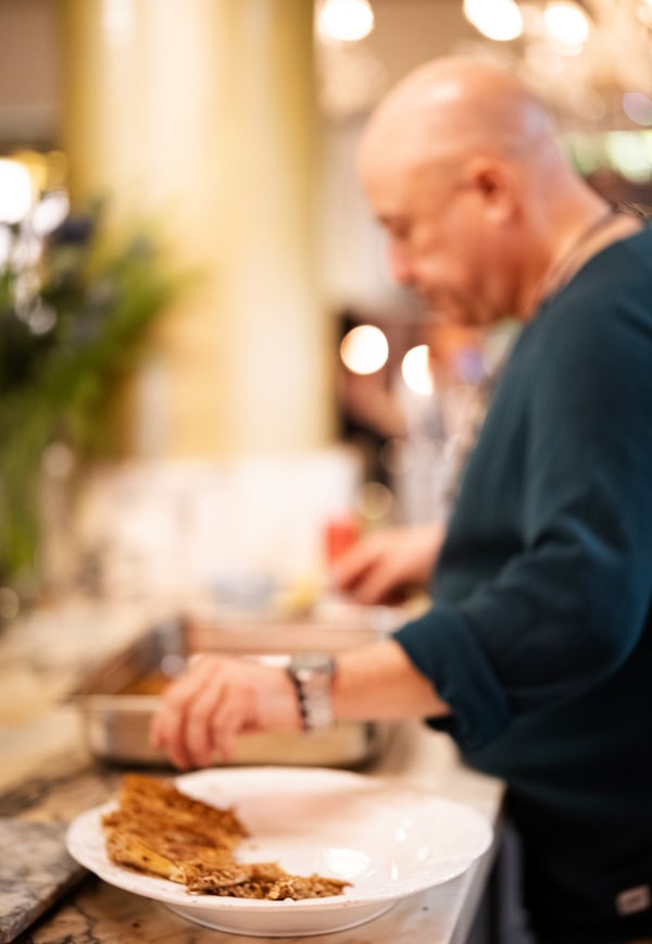 A chef preparing food beside the guests