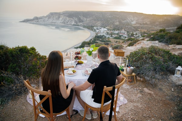 A couple together at the picnic table overlooking the bay