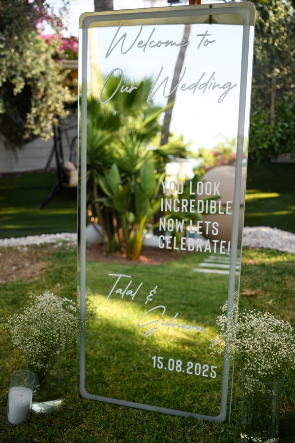 A mirrored wedding welcome sign in the garden