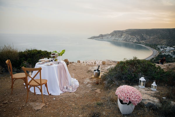 A table for two with pink details overlooking a coastal bay