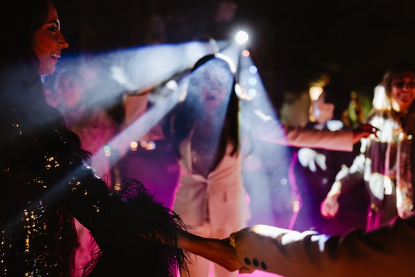 Performers and guests dancing beneath the evening lights