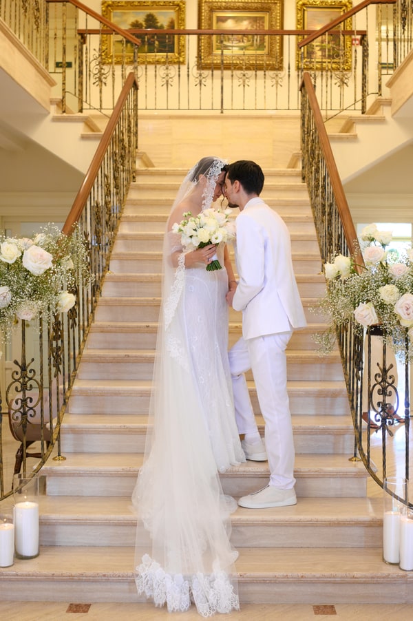 The bride and groom together on the flower-decorated staircase