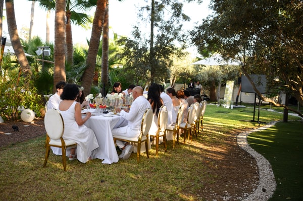Guests gathered around the long wedding table in the garden