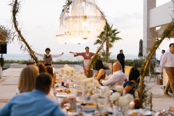 Dancers performing beside the reception table and glowing chandeliers