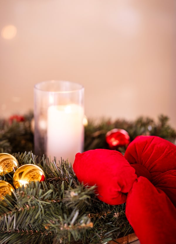 Candles, red ribbons and evergreen branches on the table
