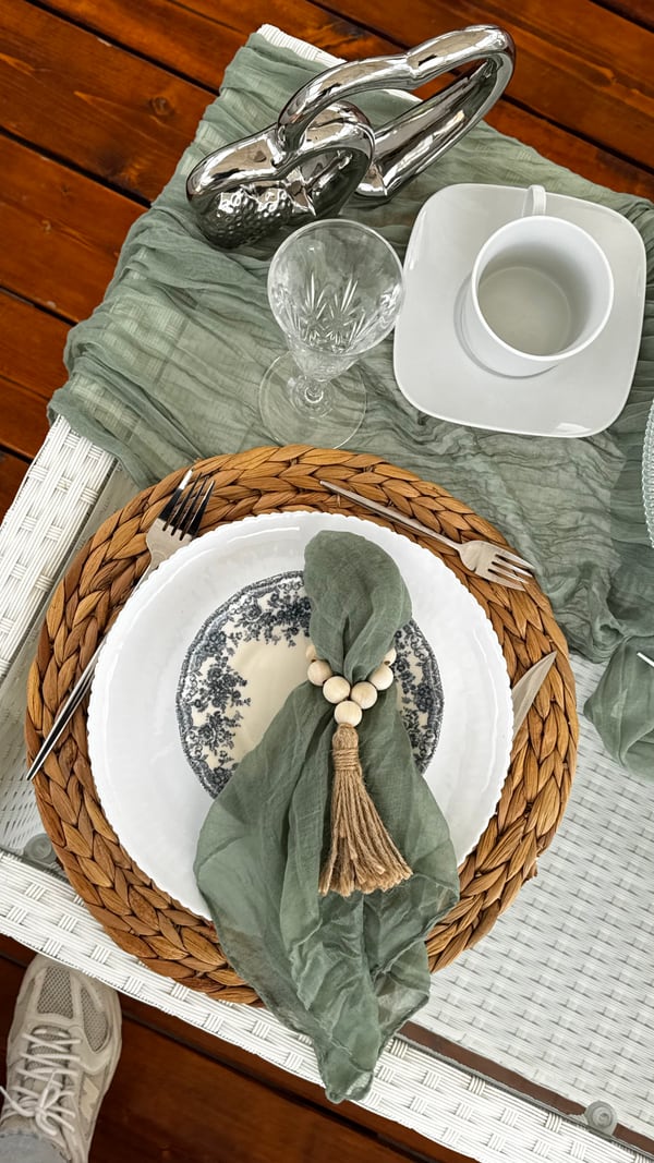 White plates, sage napkins and woven placemats