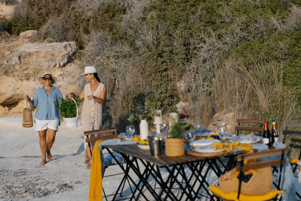 Women arranging the picnic beside the rocky shore