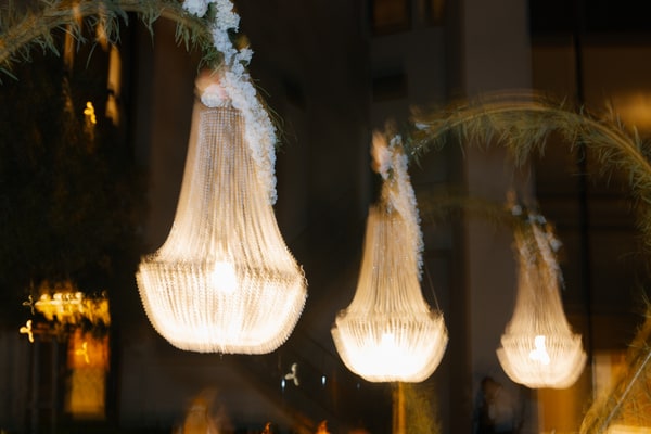 Suspended crystal chandeliers glowing at the evening reception