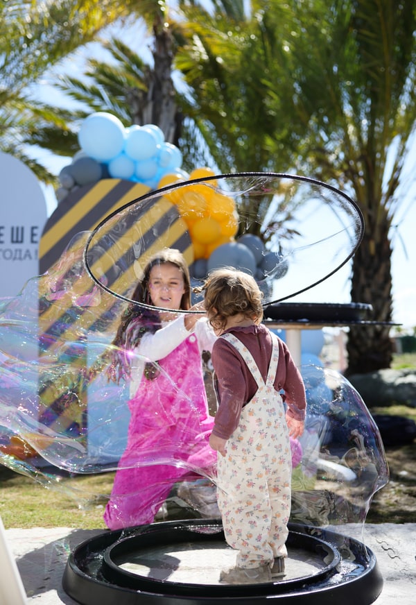 An entertainer creating large soap bubbles with children
