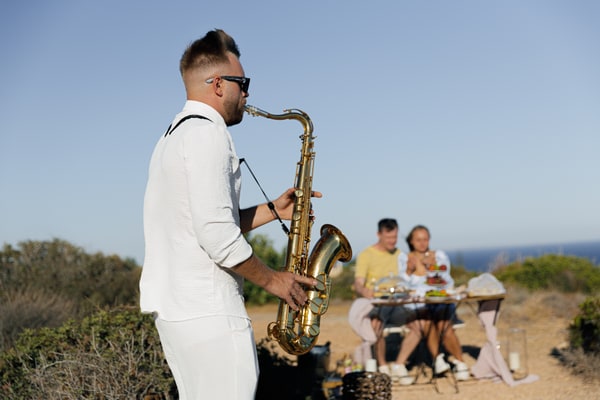 A saxophonist performing at the seaside picnic