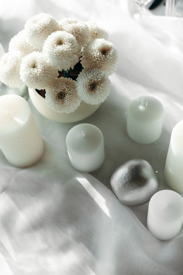 White flowers, silver ornaments and candles on the celebration table