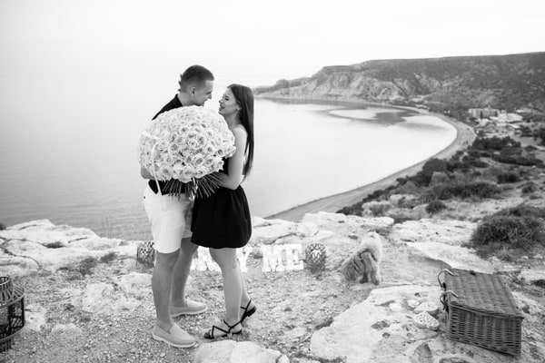 The couple embracing with a bouquet of pink roses