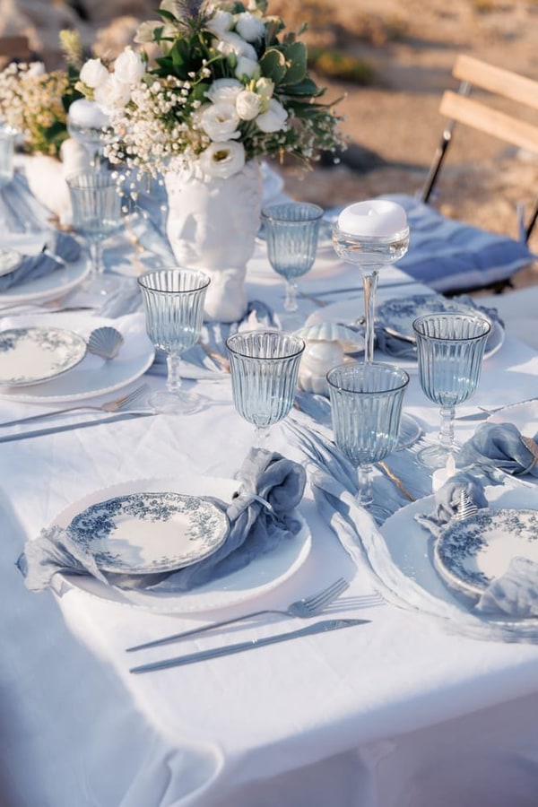 White flowers, blue plates and pale-blue glasses on the anniversary table