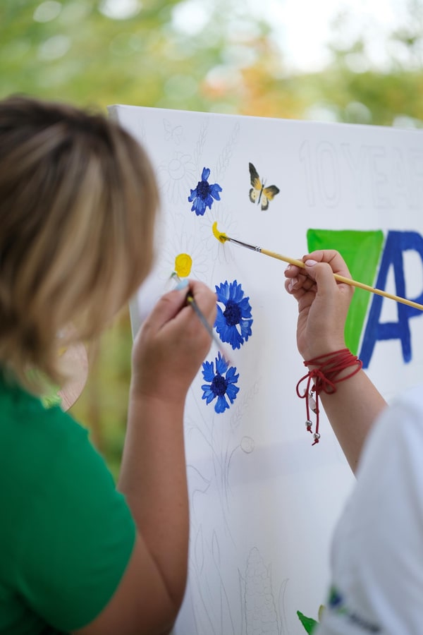 Participants painting together at outdoor easels