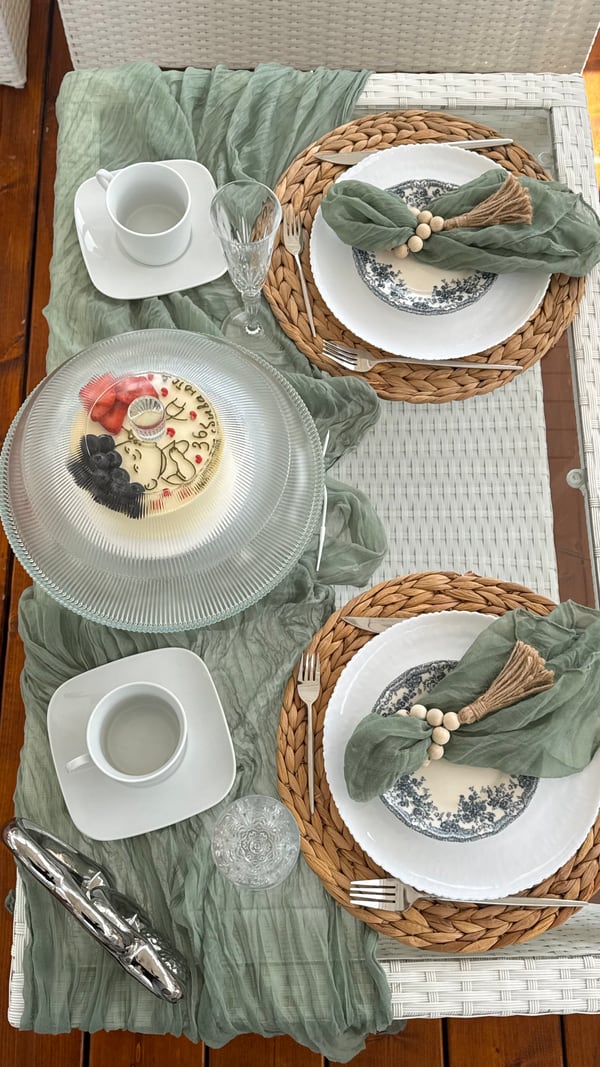 White plates, sage napkins and woven placemats