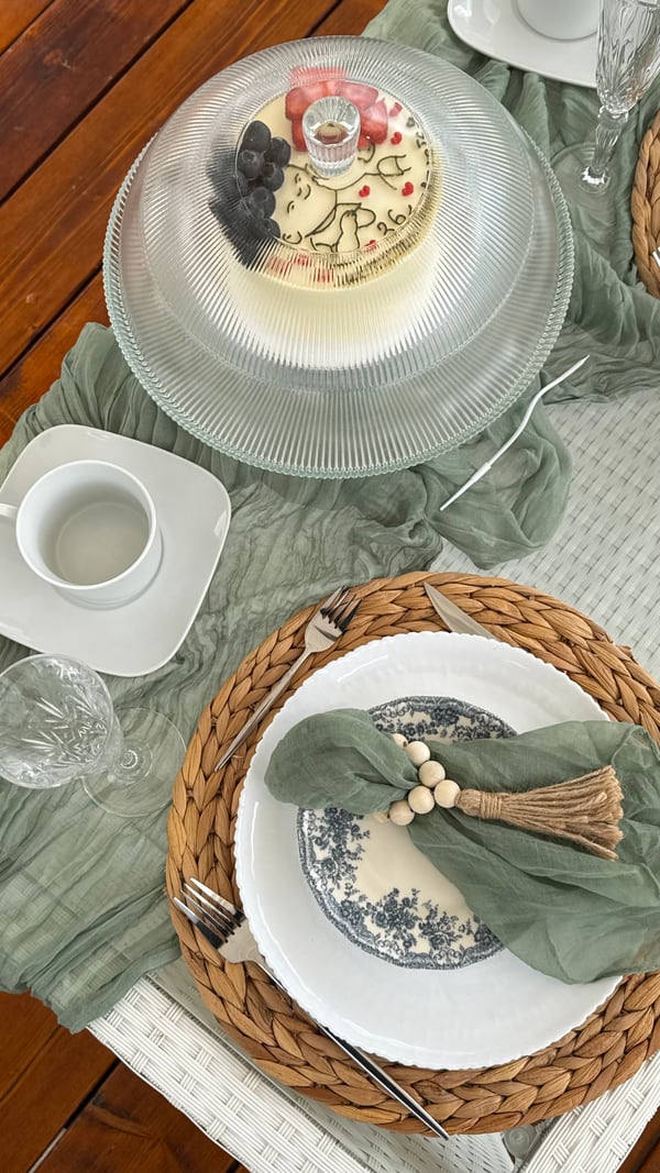 White plates, sage napkins and woven placemats