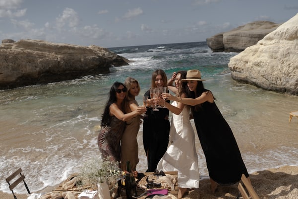 Guests posing together beside a picnic table in a rocky cove