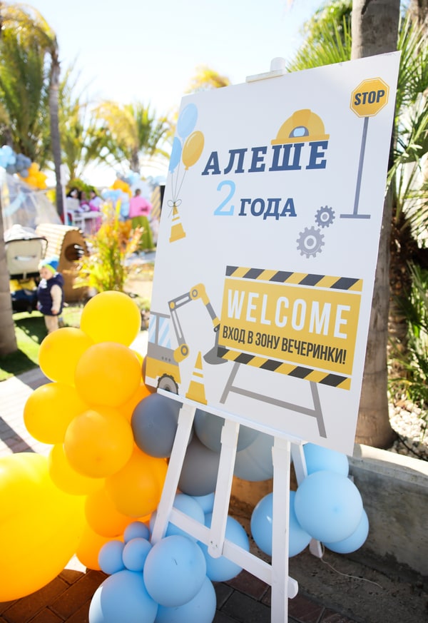 Blue and yellow balloons around a construction-themed birthday display