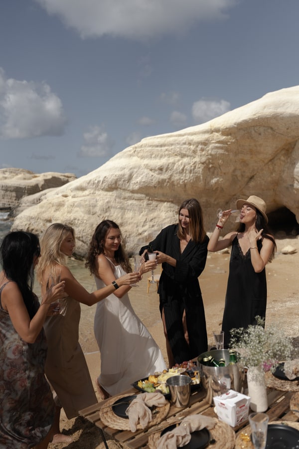Guests posing together beside a picnic table in a rocky cove