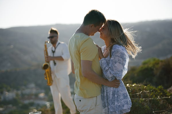 A couple enjoying live saxophone music above the sea