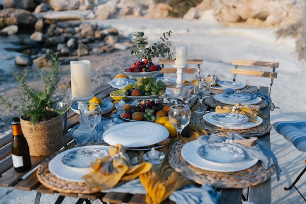 Blue-and-white plates, yellow accents and fruit on a seaside picnic table