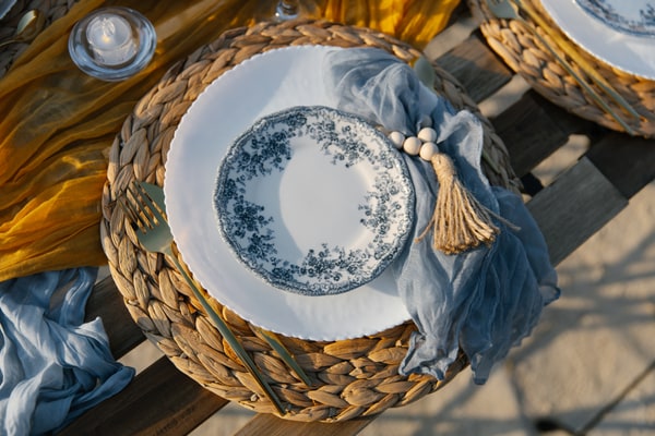 Blue-and-white plates, yellow accents and fruit on a seaside picnic table