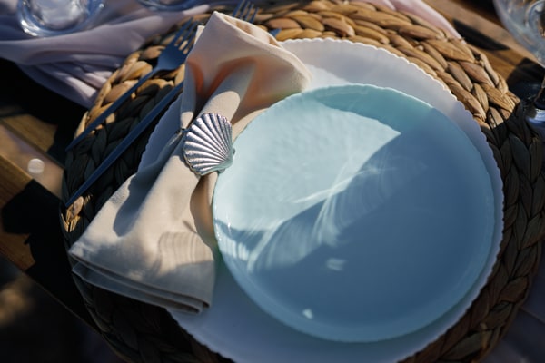 A seaside table with pale pink fabric and white place settings
