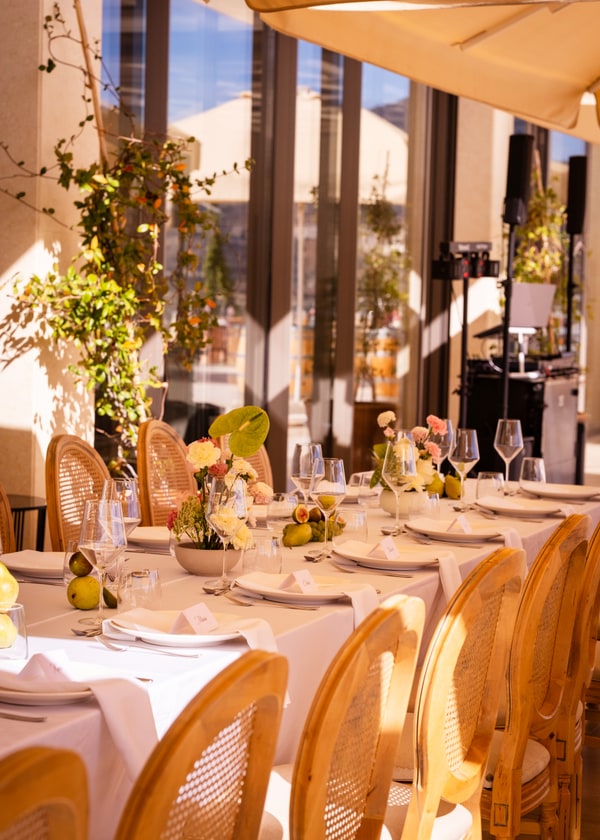 A pale pink table setting with flowers and fruit