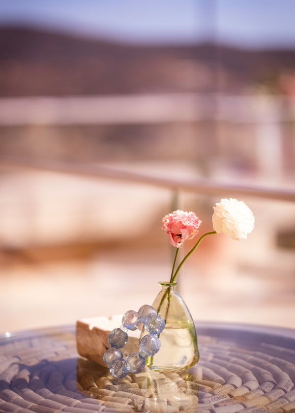 A pale pink table setting with flowers and fruit