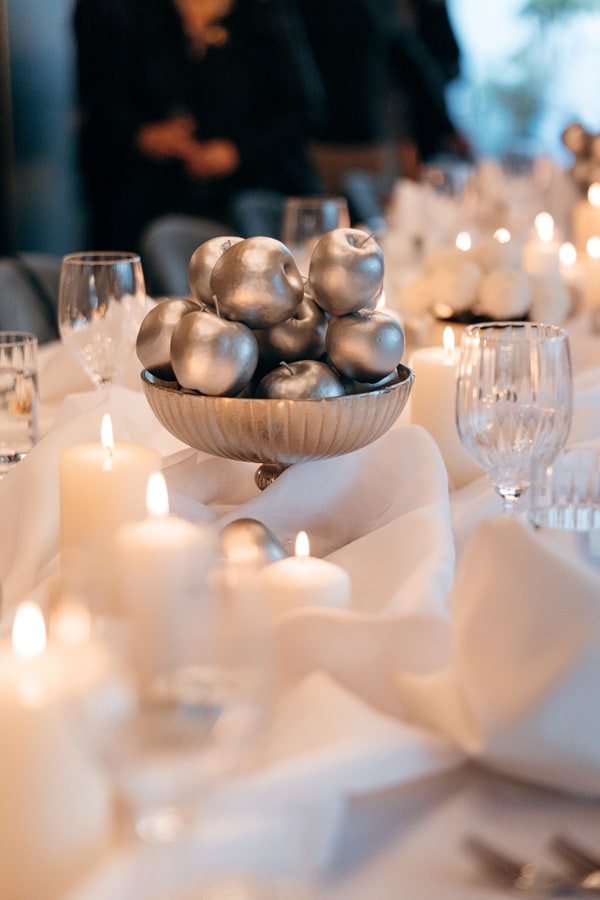 White flowers, silver ornaments and candles on the celebration table