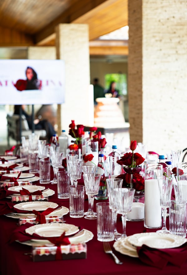 Red flowers, glassware and candles on the birthday table