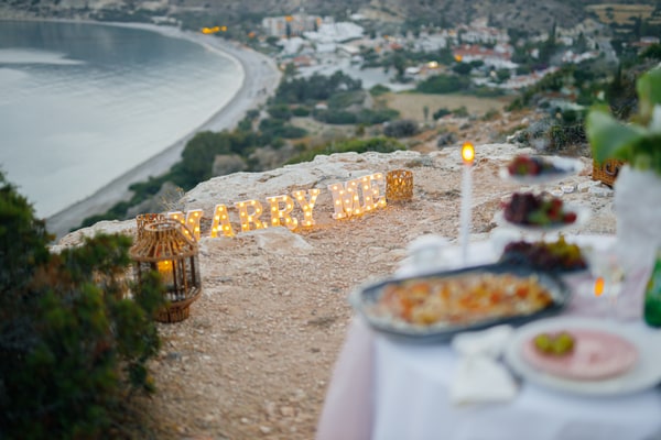 The picnic table and illuminated Marry Me letters at dusk