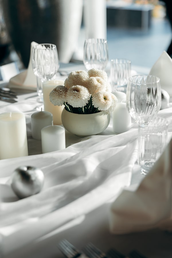 White flowers, silver ornaments and candles on the celebration table