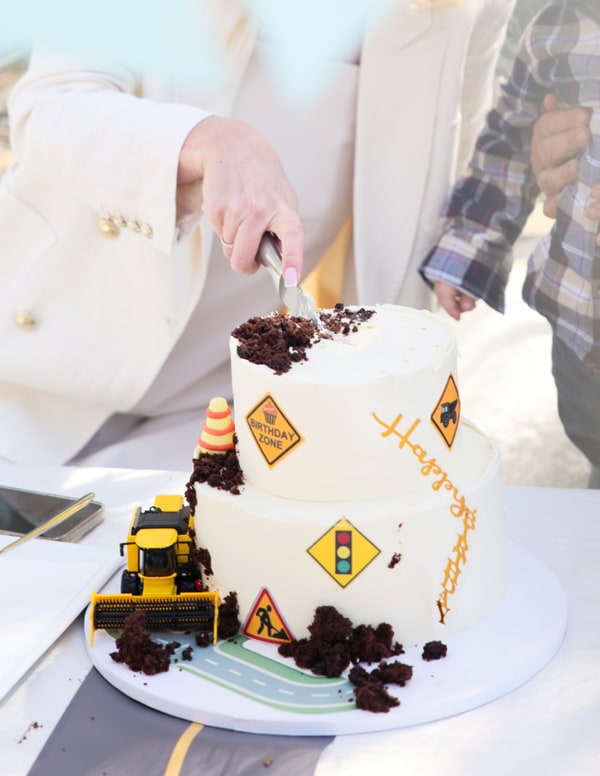 A birthday cake decorated with miniature construction vehicles