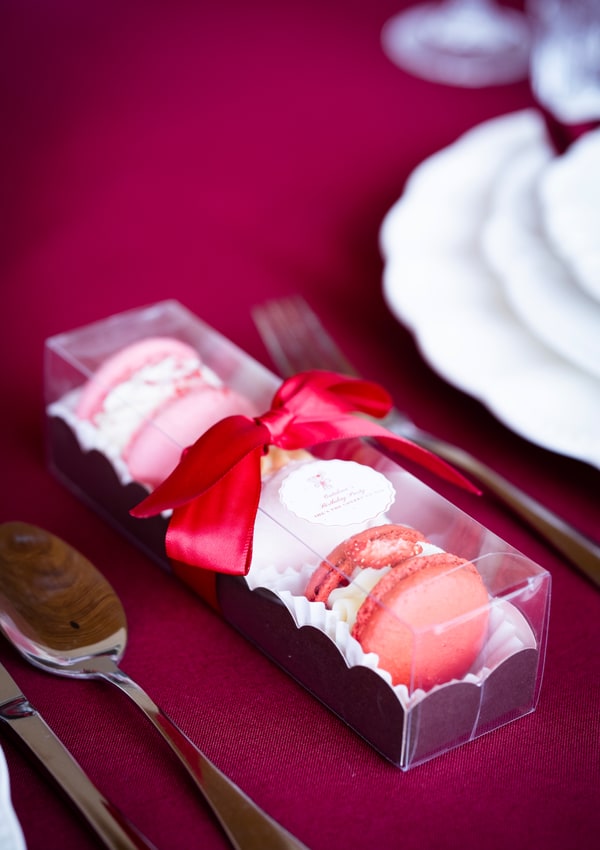 A pink gift box with a red ribbon
