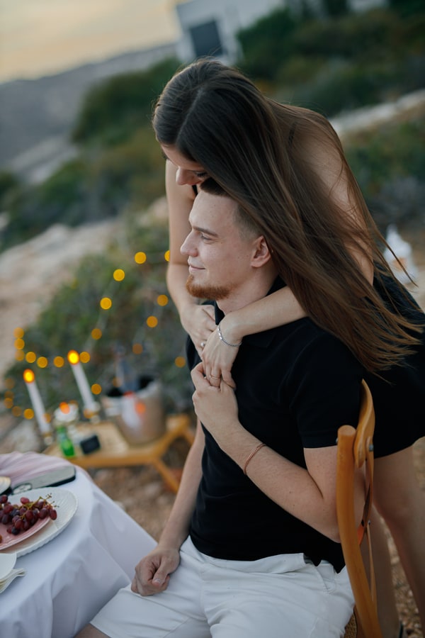 A couple together at the picnic table overlooking the bay