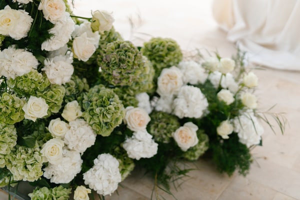 White roses and green hydrangeas arranged beside the ceremony space