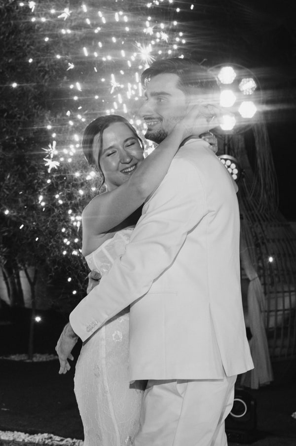 The newlyweds dancing together under evening lights