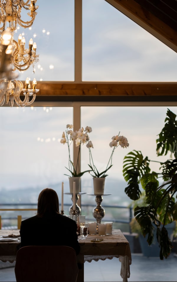 A couple at a candlelit table beside large windows