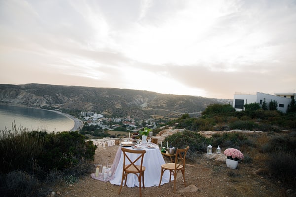 A table for two with pink details overlooking a coastal bay