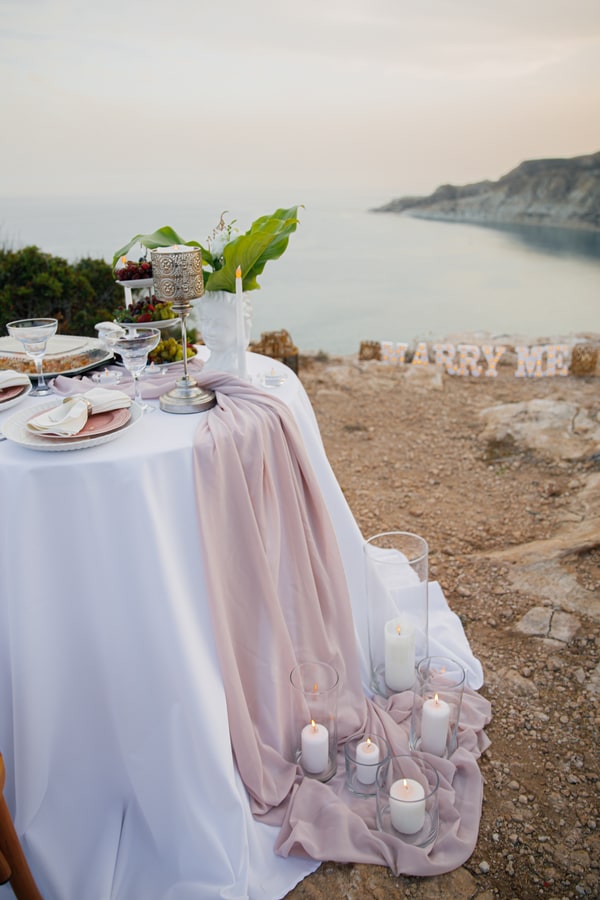 A table for two with pink details overlooking a coastal bay