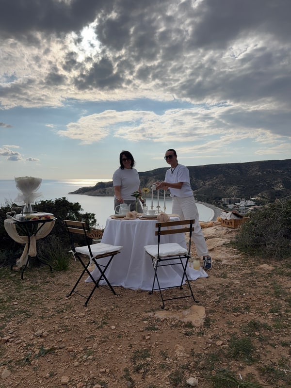A couple seated at the picnic table overlooking the sea