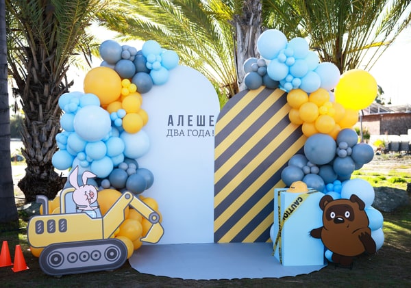 Blue and yellow balloons around a construction-themed birthday display