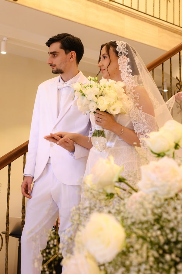 The bride and groom together on the flower-decorated staircase