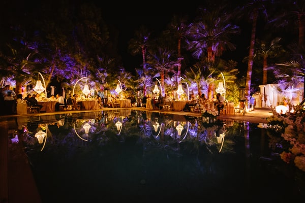The poolside celebration with chandeliers and a lit stage